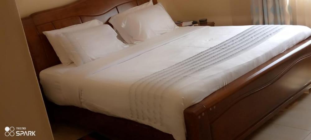 利隆圭Stream Box Lodge的一张配有白色床单和枕头的大床