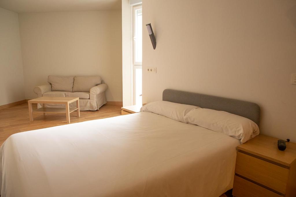 毕尔巴鄂Apartamentos Lidar的卧室配有白色的床和沙发