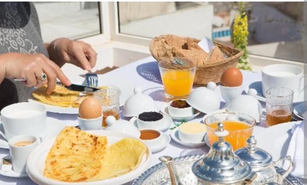 阿加迪尔Riad dar salam的一张桌子,上面放着鸡蛋和早餐食品