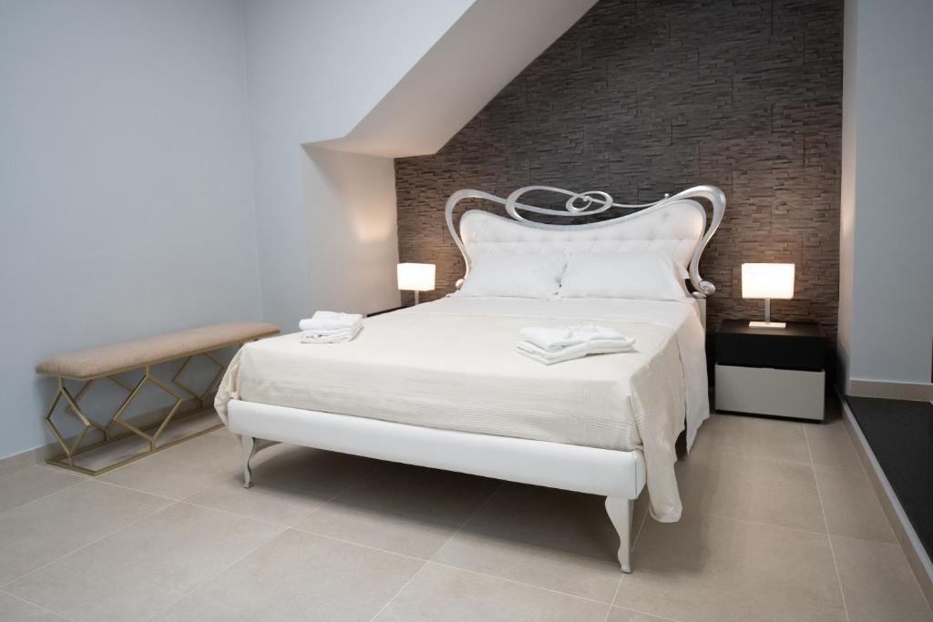 卡塔尼亚iitana Luxury Apartment - Catania Fronte Mare的卧室配有白色的床和砖墙