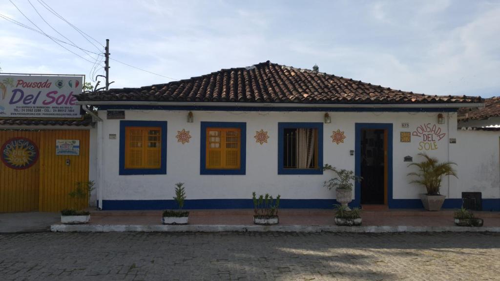 安格拉杜斯雷斯Pousada del Sole的白色的小房子,有蓝色和黄色的门