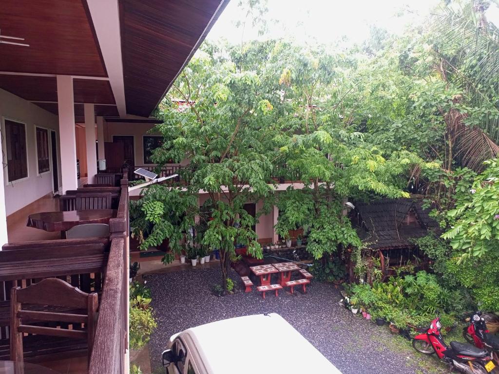 Ban Nahin-Nai (2)Phamarn View Guesthouse的树和长凳的房屋门廊