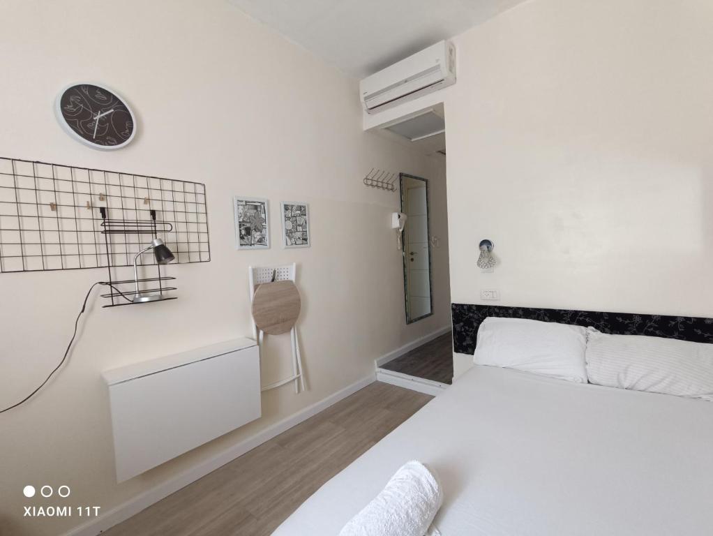 特拉维夫Private rooms near the beach center的卧室配有一张床,墙上挂着一个钟