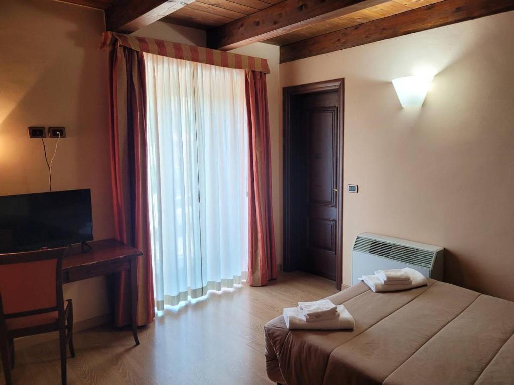 PreturoLocanda San Pietro的一间卧室配有一张床、一张书桌和一个窗户。