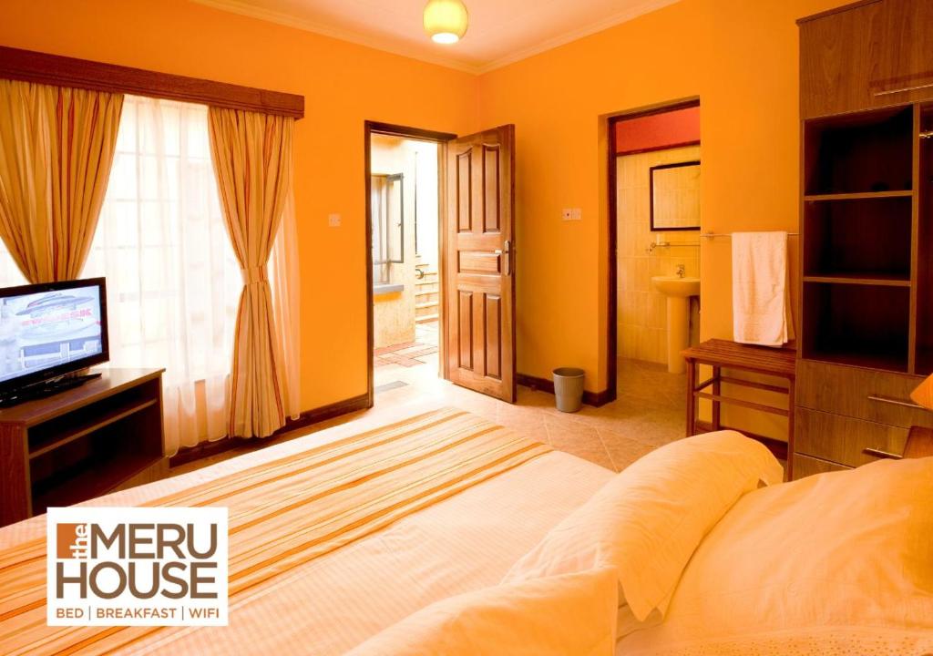 NkubuThe Meru House的一间卧室设有橙色的房子,配有一张床和电视
