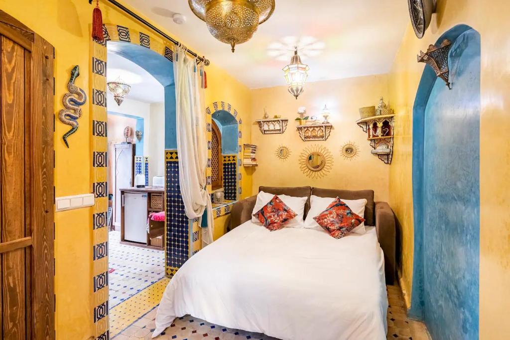 丹吉尔Dar Sandra Moroccan Tiny House的卧室设有白色的床和黄色的墙壁
