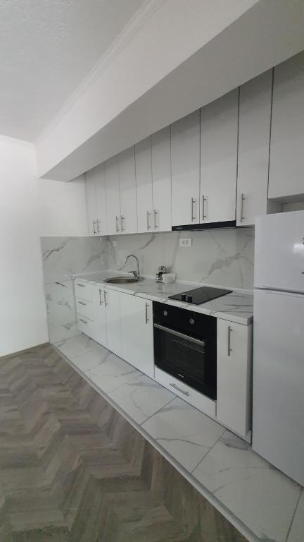 奥赫里德Flat in Trpejca的厨房配有白色橱柜和黑色用具