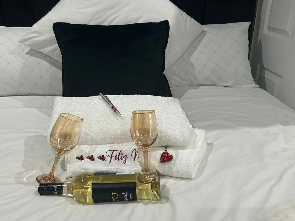 索韦托Serenity Guest House的一张带一瓶葡萄酒和两杯酒的床