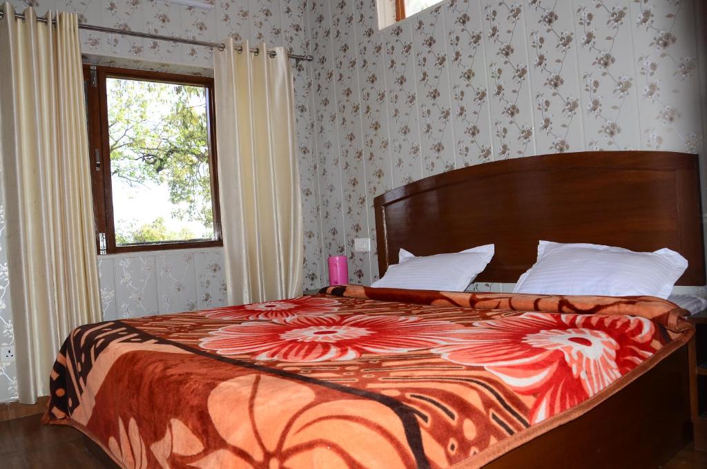 穆索里Bhandari Homestay and Restaurant的一间卧室配有一张带花卉床罩的大床