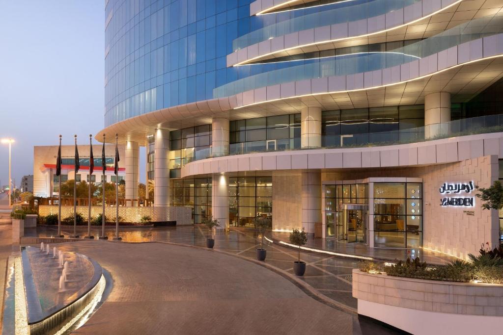 利雅德Le Meridien Riyadh的前面有圆形车道的大型办公楼