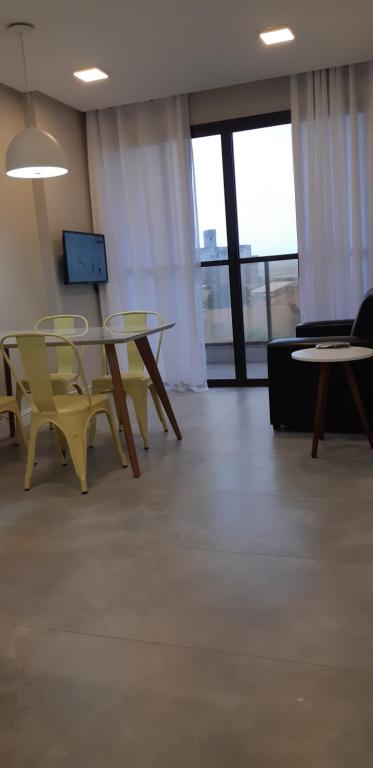 安谢塔Ap 305 Praia Castelhanos的配有桌椅和沙发的房间