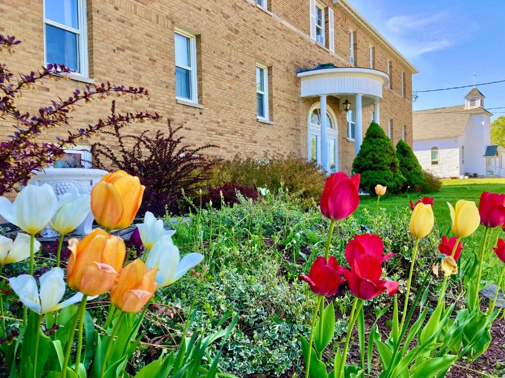 GardenGarden Grove Retreat & Lodging near Pictured Rocks, Fayette, Trails的一座房子前面的鲜花花园