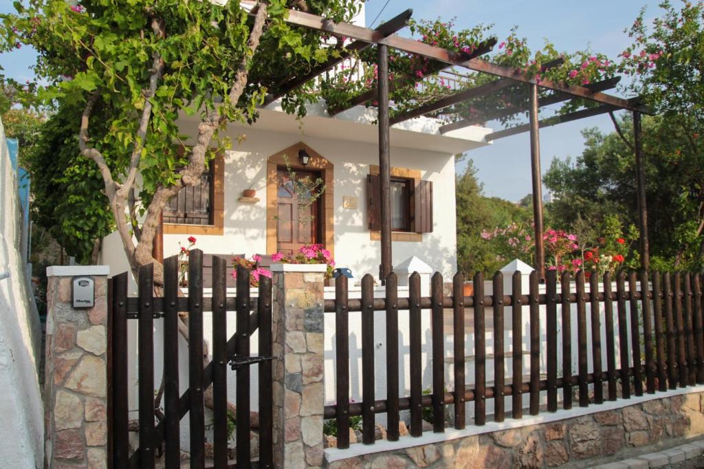 阿彻奇洛斯Villa Nefeli Rhodes的鲜花盛开的小房子前面的围栏