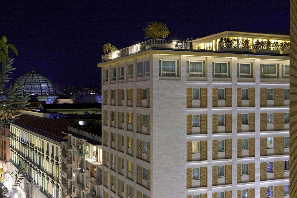 那不勒斯地中海那不勒斯万丽酒店的一座晚上有灯的建筑