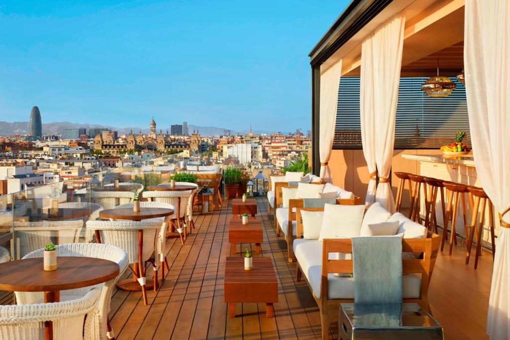 巴塞罗那巴塞罗那艾迪逊酒店的设有带桌椅的市景阳台。