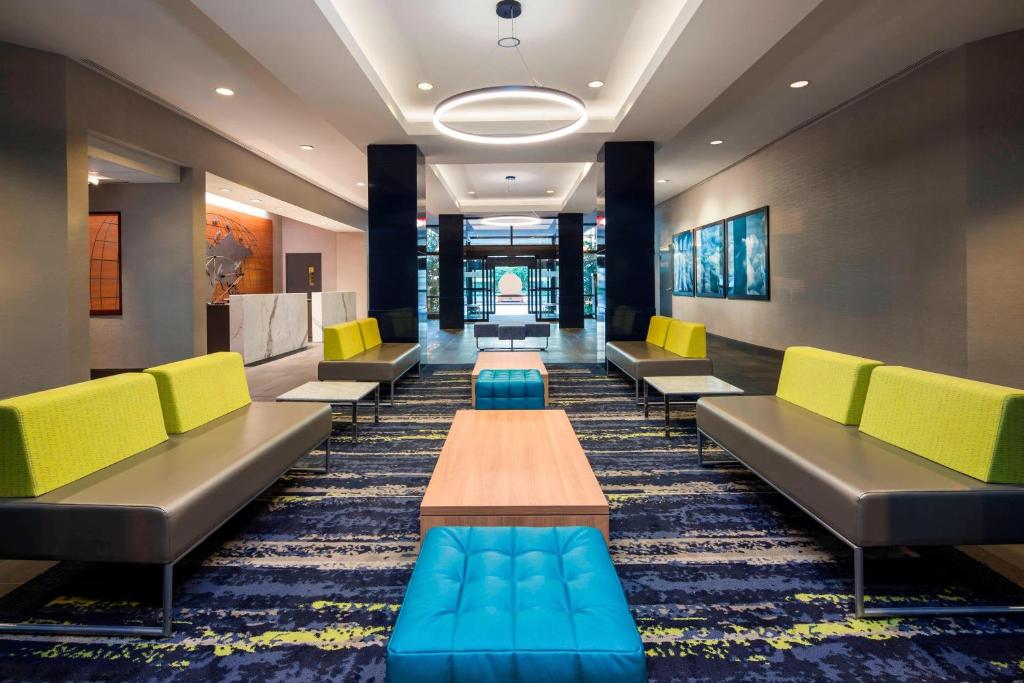 费城费城机场喜来登套房酒店的一间设有黄色和蓝色椅子和桌子的等候室