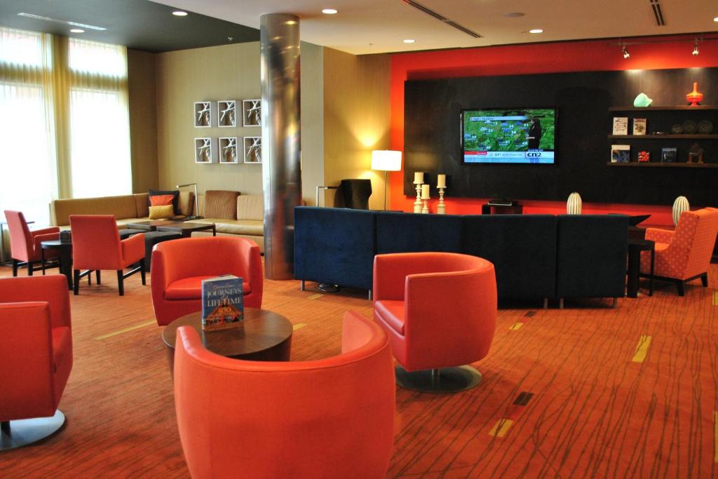 埃文斯维尔埃文斯维尔东埕万怡酒店的一间设有红色椅子和电视的等候室