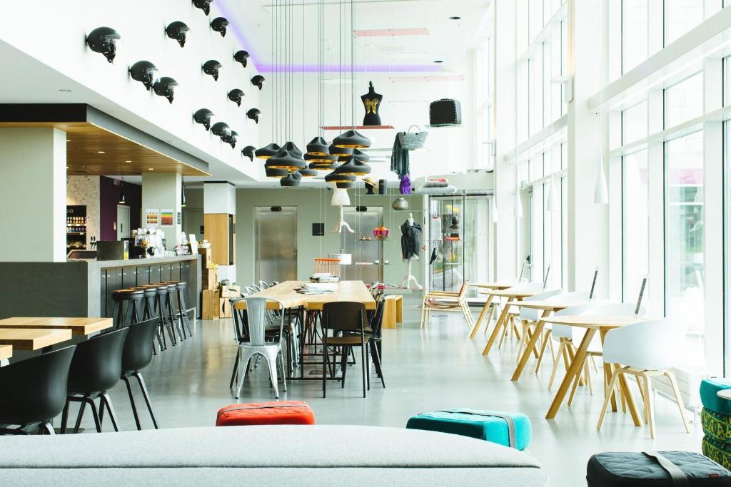 卡萨诺韦米兰马尔彭萨机场慕奇夕酒店的餐厅设有桌椅和窗户。