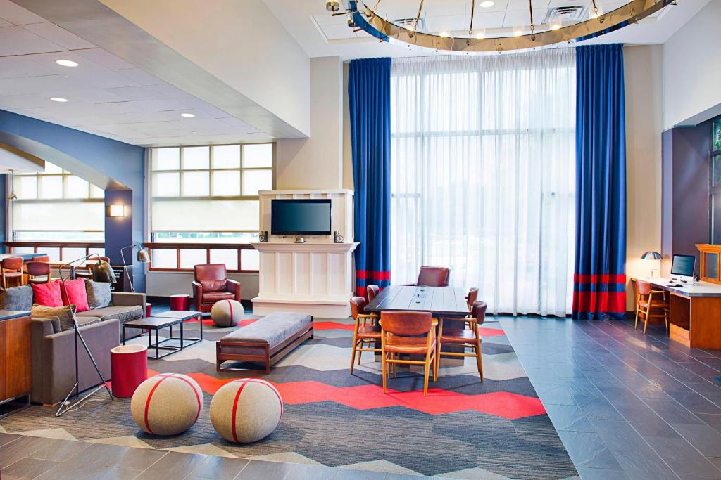 费城费城机场福朋喜来登酒店 的客厅配有电视、沙发和椅子