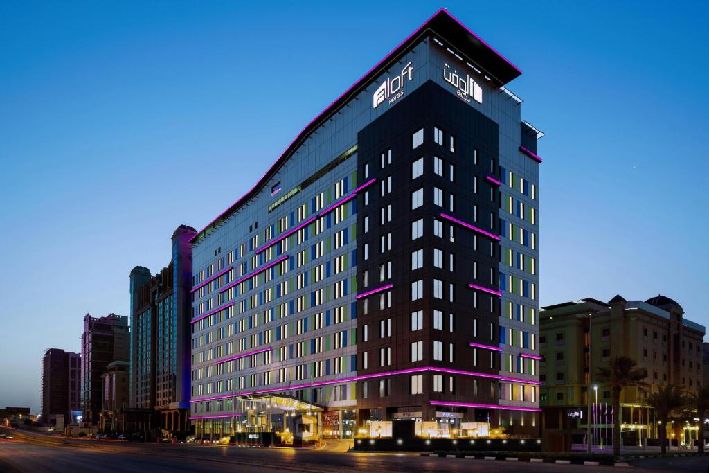 阿可贺巴雅乐轩达兰酒店的一座高大的黑色建筑,上面有紫色的灯