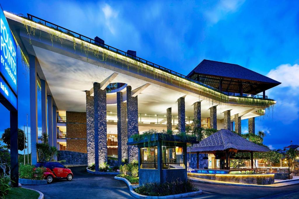 库塔库塔巴厘福朋喜来登酒店的一栋建筑前停着一辆车