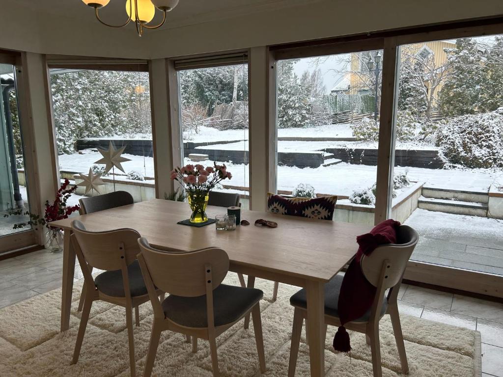 斯德哥尔摩Villa Stockholm Täby的一间带木桌和椅子的用餐室