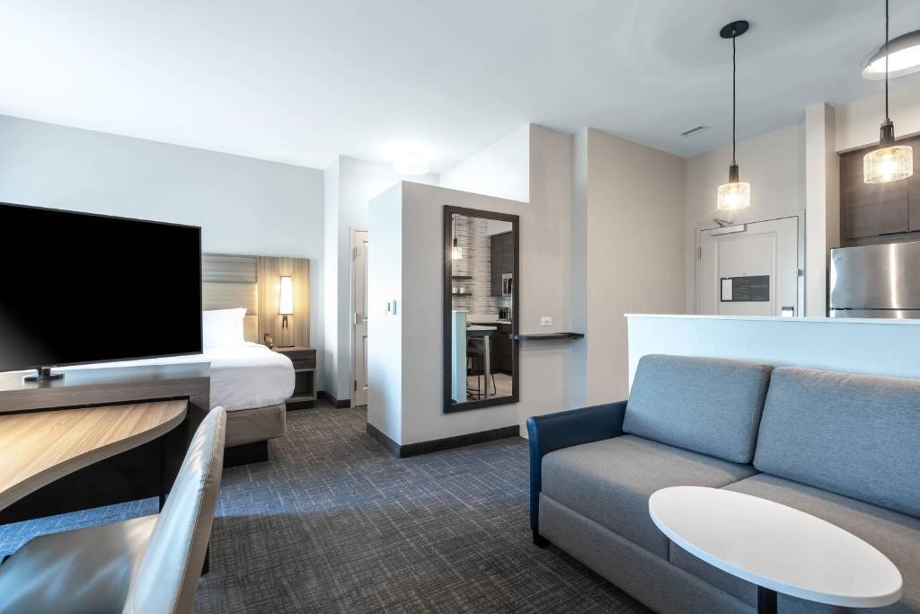 安德森Residence Inn by Marriott Anderson Clemson的酒店客房配有床、沙发和电视。