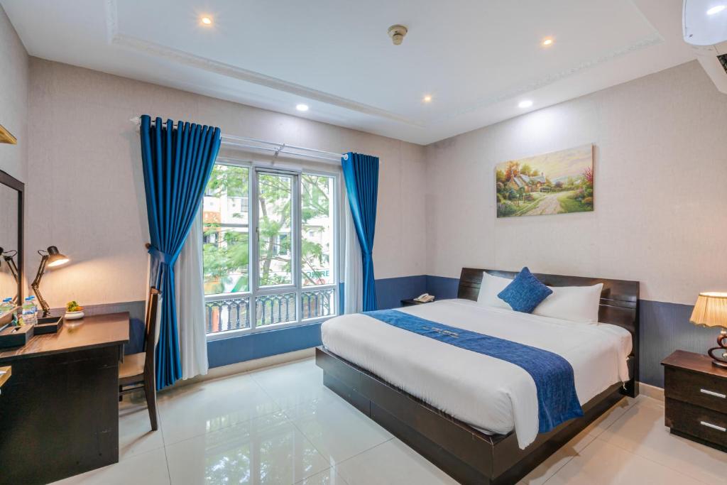 胡志明市La Serena Hotel & Apartment的一间卧室配有一张床、一张书桌和一个窗户。