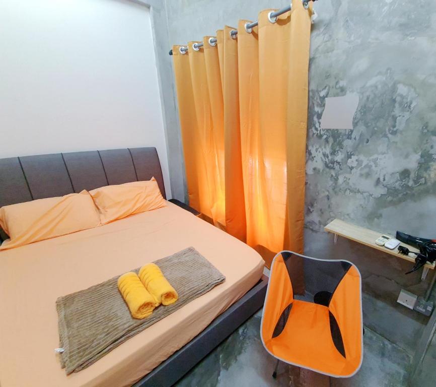 芙蓉Lot 85 Seremban Town New Cozy Homestay Lobak的一间卧室配有一张带两张黄色毛巾的床