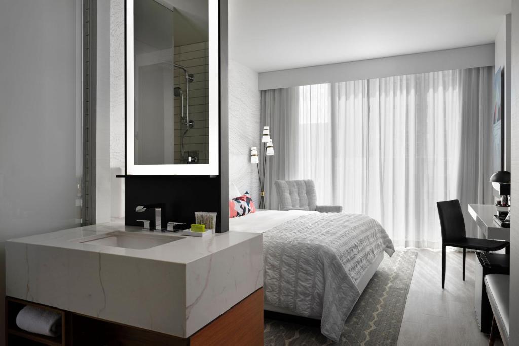 丹佛丹佛市中心艾美度假酒店的一间卧室配有床、水槽和镜子