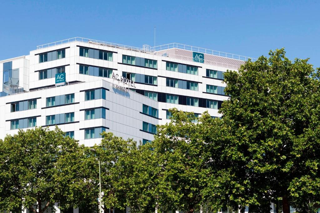 巴黎巴黎马约门站万豪AC酒店的一座高大的白色建筑,前面有树木