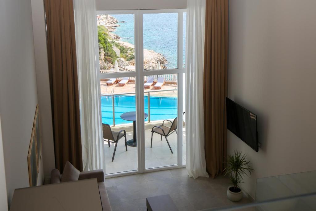 伏罗拉Toto Boutique Hotel & Apartments的客房设有海景大窗户。