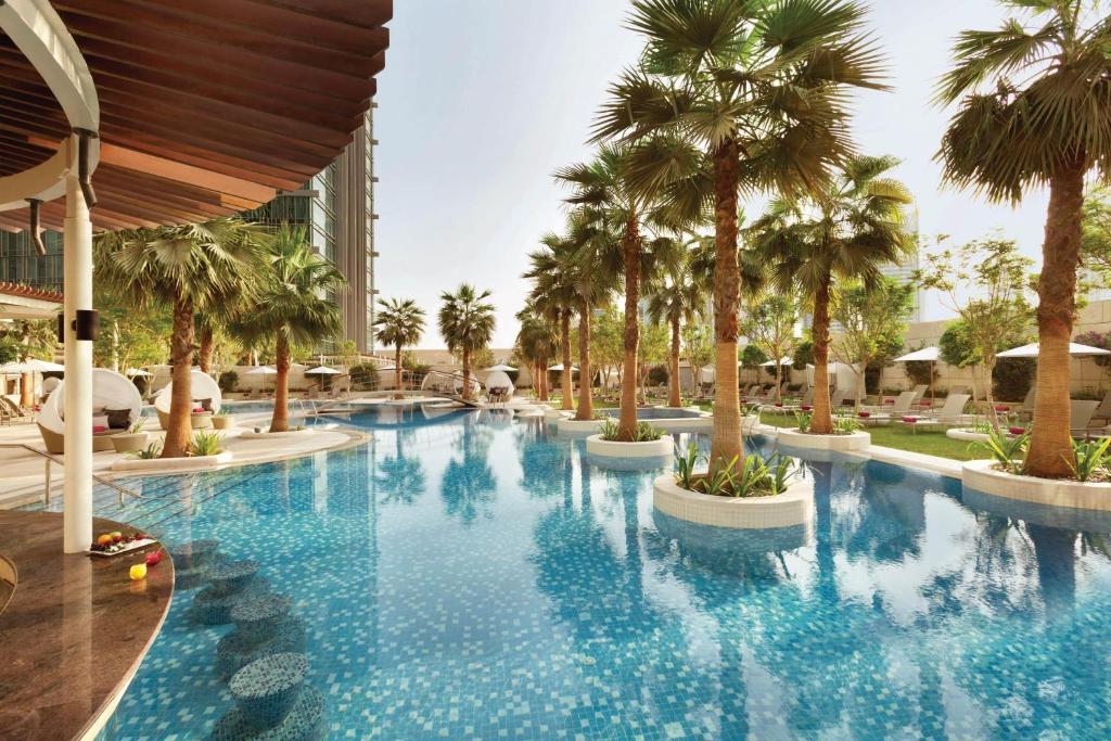多哈JW Marriott Marquis City Center Doha的度假村内棕榈树游泳池