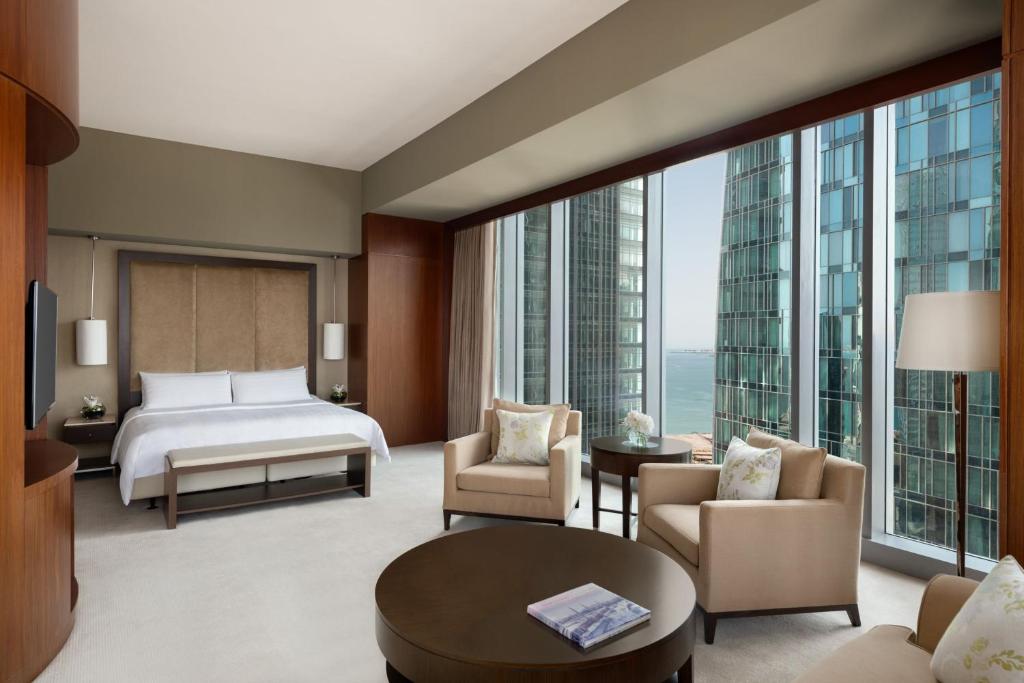 多哈JW Marriott Marquis City Center Doha的酒店客房设有一张床和一个大窗户