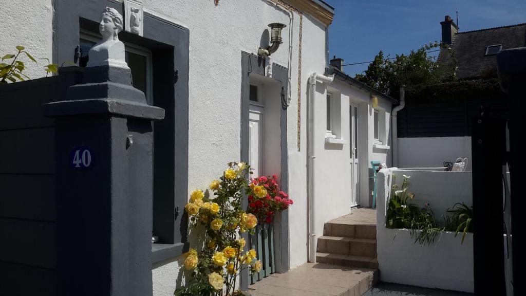 瑟堡Maison cosy vue sur la rade Tourlaville的白色的房子,上面有一扇鲜花门