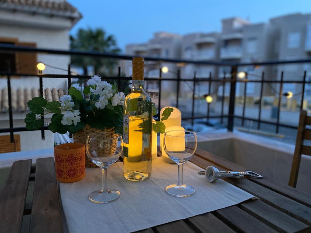 圣波拉LOVELY Sunset的一张桌子上摆放着一瓶葡萄酒和两杯酒杯
