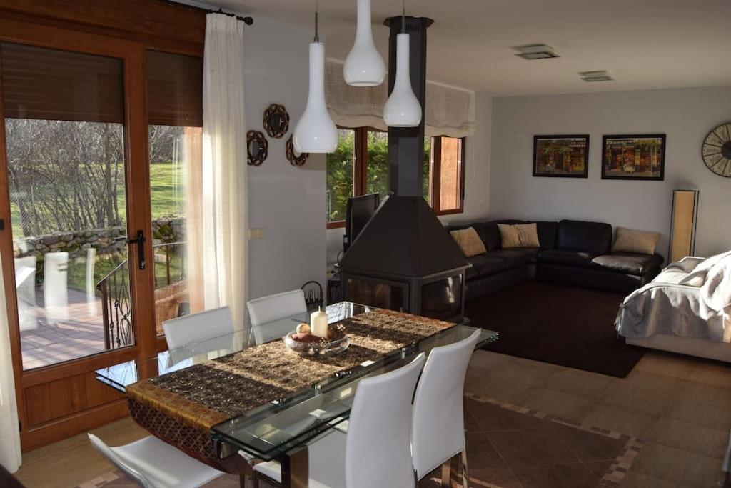 拉斯卡弗里亚Casa con jardín en Rascafría的一间带桌子的客厅和一间带沙发的客厅