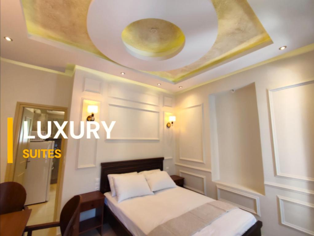 沃洛斯Villa Miltiadis GreeceFyloxenia的酒店客房设有一张床和一个带标志的天花板