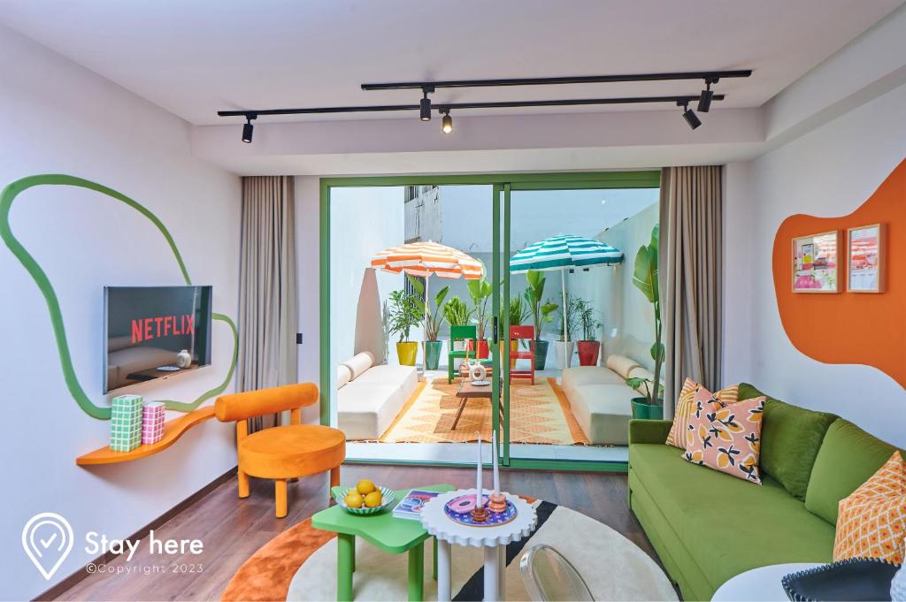 卡萨布兰卡Stayhere Casablanca - CIL - Vibrant Residence的客厅配有绿色沙发和桌子