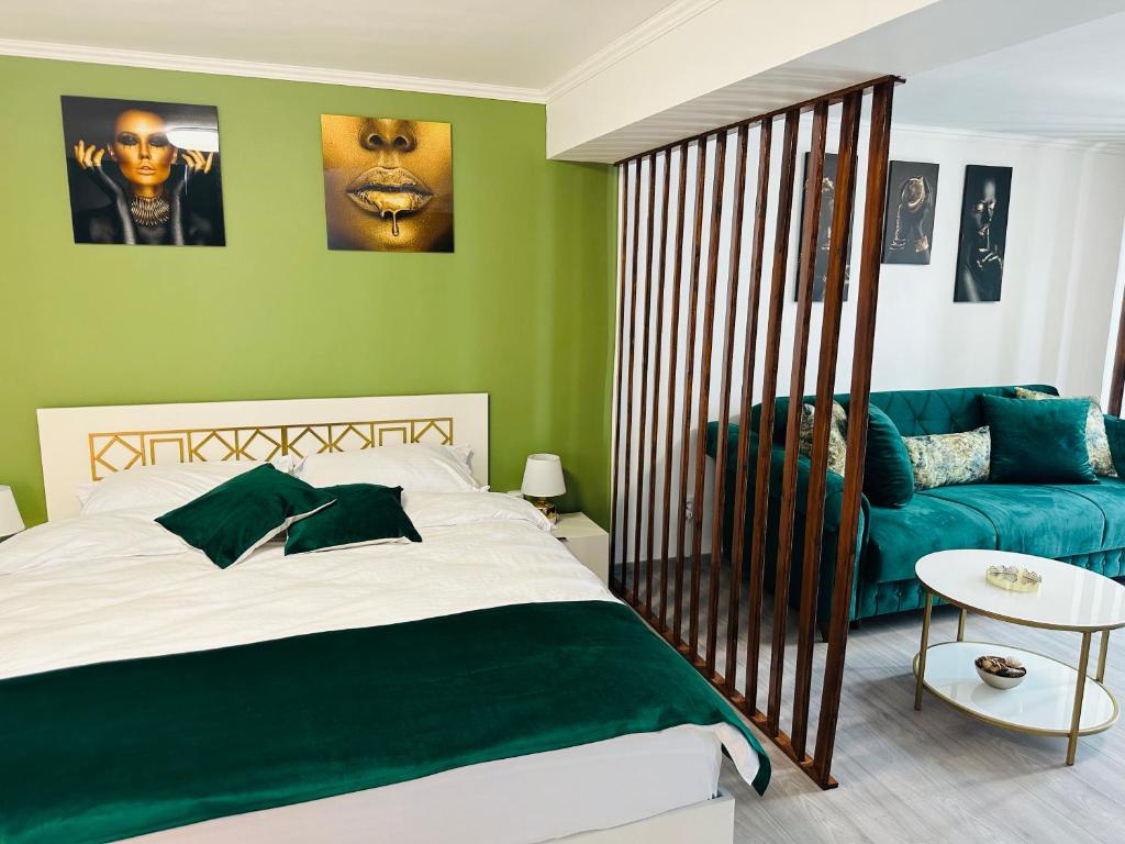 锡比乌Luxor Apartament Sibiu的一间卧室设有绿色的墙壁、一张床和一张沙发