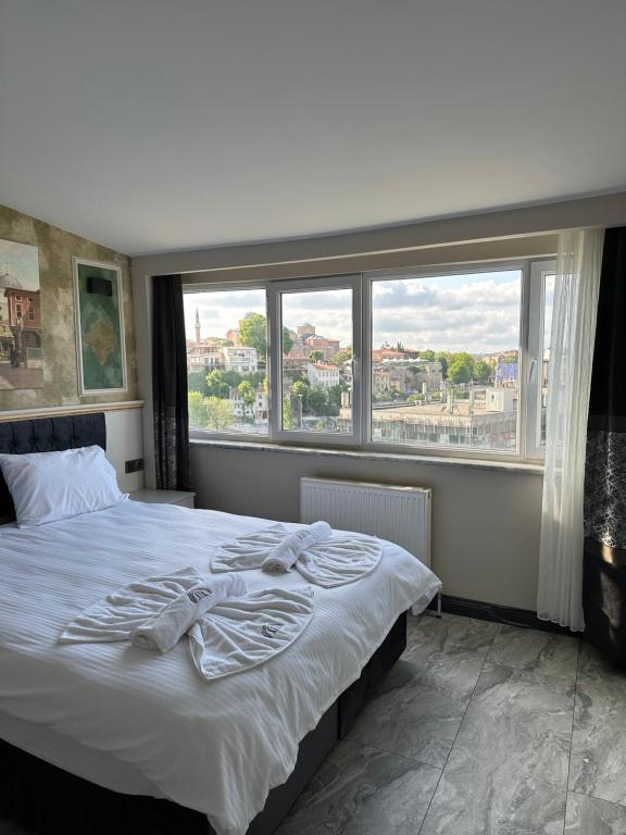伊斯坦布尔Mar Boutique Apartment的一间卧室设有一张床和一个大窗户