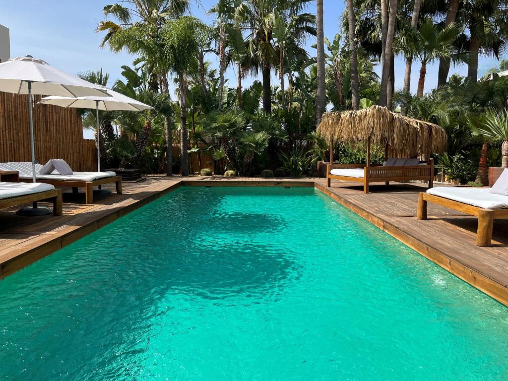 圣乔治VILLA SERENITY 3 Luxury boutique villa的度假村内带椅子和遮阳伞的游泳池