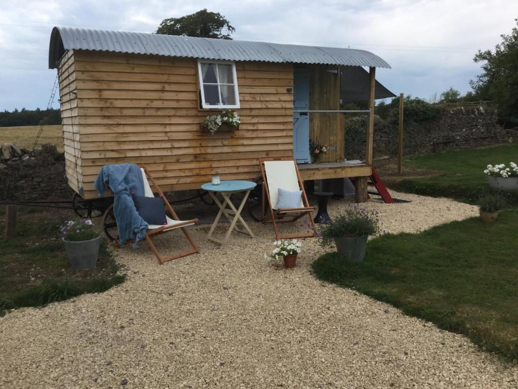 特罗布里奇Dolly’s shepherds hut的前面有桌椅的小房子