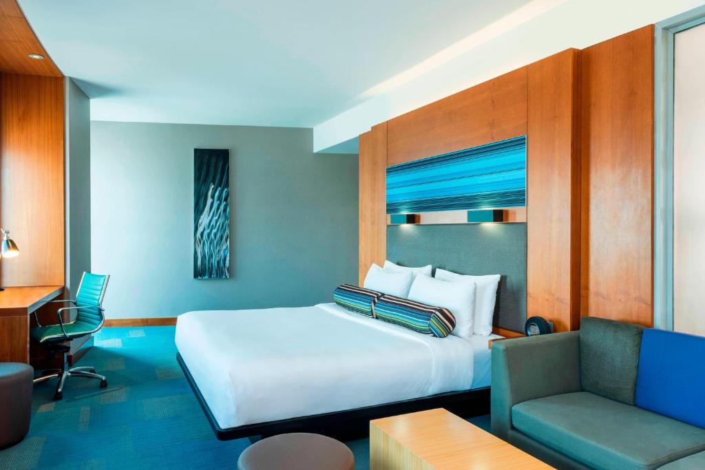 阿布扎比阿布扎比雅乐轩酒店的一间卧室配有一张床、一张桌子和一张沙发