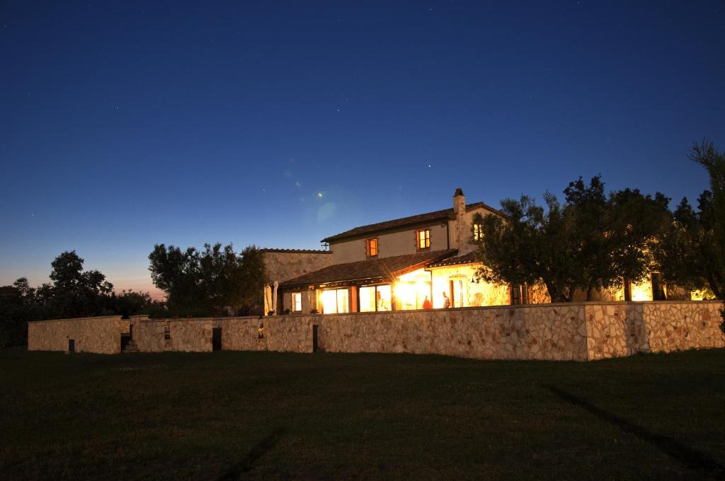 塔尔奎尼亚切利诺卢波农场乡村民宿的一座晚上有石墙的房子