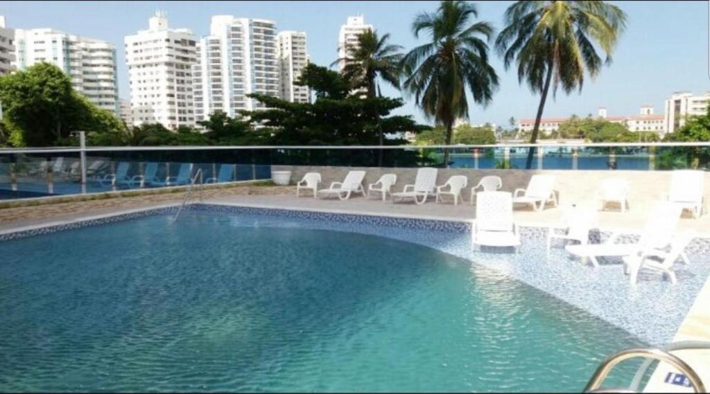 卡塔赫纳Cartagena apartamento piso 2 frente a la playa的一座带白色椅子的大型游泳池,