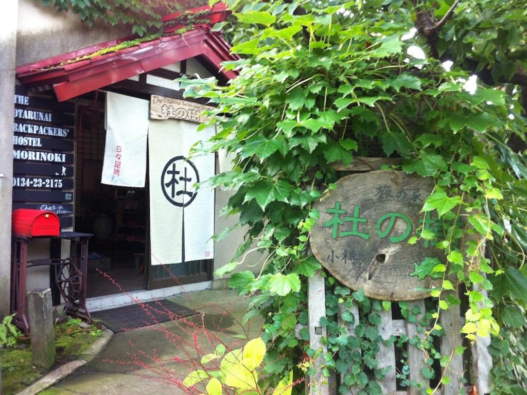 小樽The Otaornai Backpacker's Hostel Morinoki的一座绿色常春藤的建筑