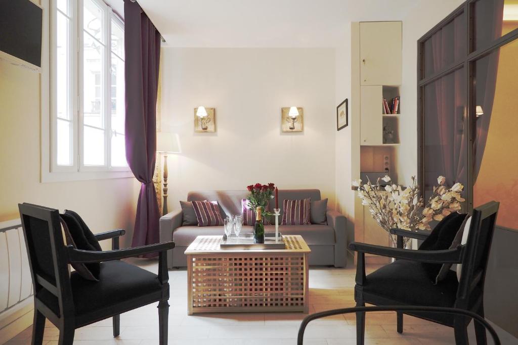 巴黎圣日耳曼优雅奇客修特斯公寓的客厅配有沙发和桌椅