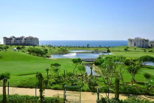 艾西拉Prestigieux Appartement à Marina Assilah Golf的享有高尔夫球场的海景
