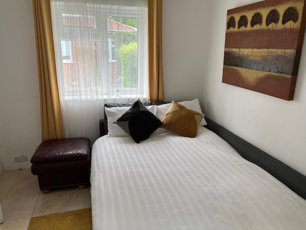 伦敦Dannifar Guest House的卧室配有带枕头的床铺和窗户。